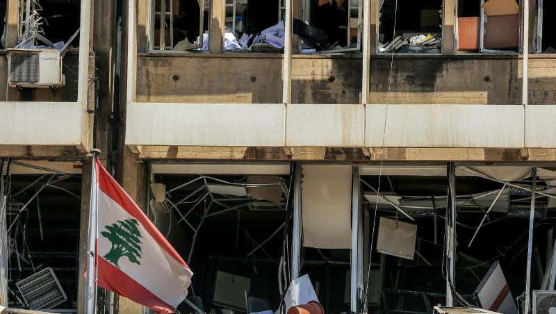 Die libanesische Flagge vor der Fassade eines zerstörten Bürogebäudes in Beirut. Die libanesische Flagge vor der Fassade eines zerstörten Bürogebäudes in Beirut.