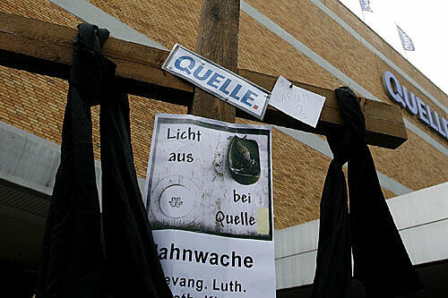 Vor dem Versandzentrum von Quelle in Fürth steht ein Kreuz &ndash; ehemalige Mitarbeiter haben es bei einer Mahnwache aufgestellt.