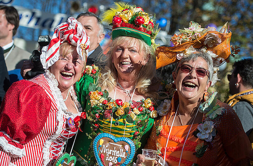 Die Marktfrauen Annemarie (l-r), Erika und Christl verfolgen am 11.11.2015 die Vorstellung des Prinzenpaares zur Faschingseröffnung am Viktualienmarkt in München (Bayern).