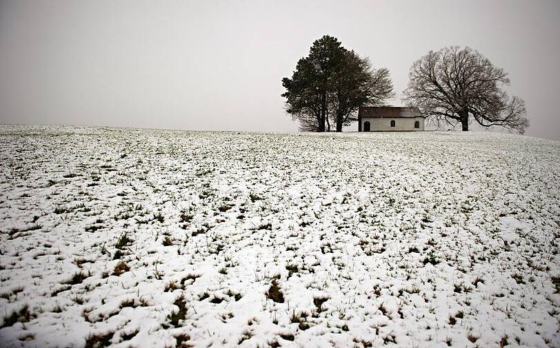 Bayern: Eine Kapelle bei Thaining im frisch gefallenen Neuschnee.