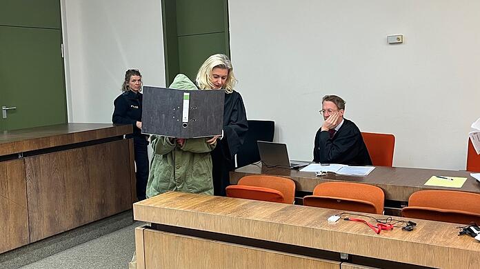 Mit einem Aktendeckel vor dem Gesicht und der Kapuze über dem Kopf betritt die Angeklagte am Donnerstag das Gericht.