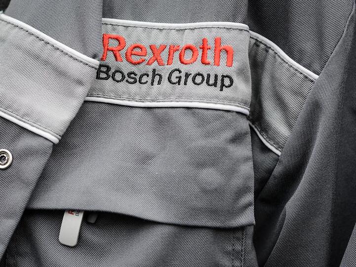 Ein Mitarbeiter trägt eine Jacke mit dem Firmenschriftzug. Foto: David Ebener/Archivbild