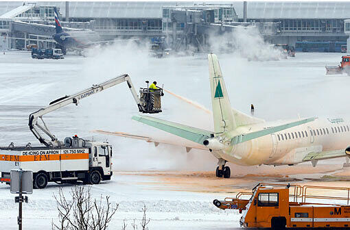 Schnee am Münchner Flughafen. Eine Maschine wird enteist. Hunderte Flüge mussten letzten Donnerstag, Freitag  und auch heute wieder gestrichen werden.