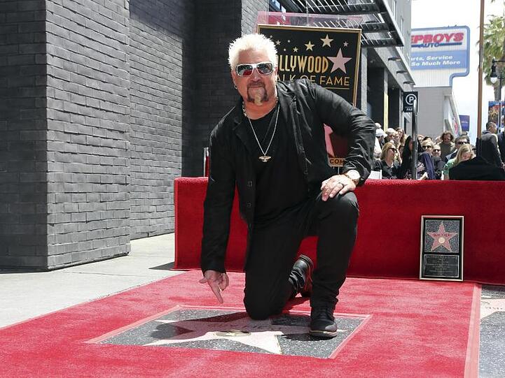 Der Star-Koch und TV-Show-Moderator Guy Fieri kniet neben seinem Stern auf dem "Walk of Fame".