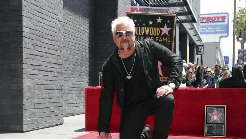 Der Star-Koch und TV-Show-Moderator Guy Fieri kniet neben seinem Stern auf dem "Walk of Fame".