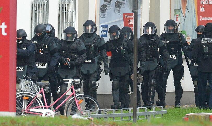 Mit erhobenen Händen kommt ein Mann auf die SEK-Beamten zu, im Hintergrund lauern Heckenschützen der Polizei. Die Beamten nehmen den Mann fest, es ist aber nicht der Täter, der sich in einem Imbiss in Freiburg veschanzt hat.
