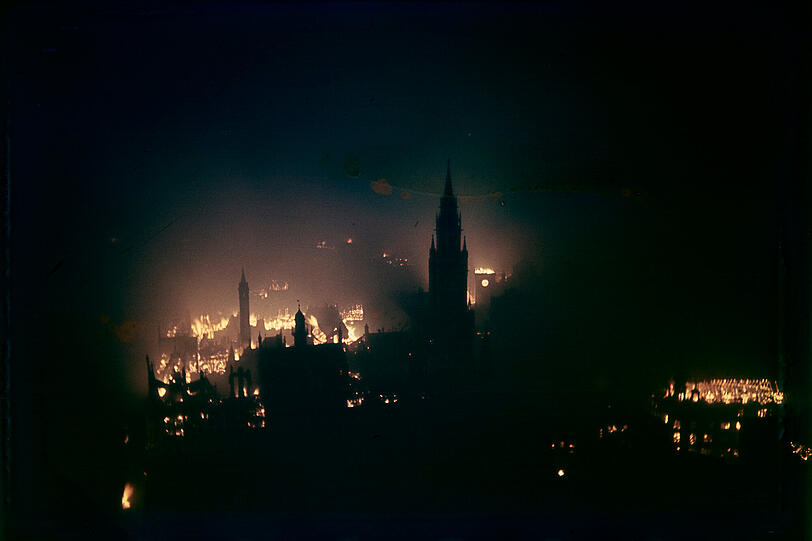Clemens Bergmann fotografierte heimlich, meist von der Frauenkirche. Hier das Neue Rathaus vor brennender Stadt, 1943/1944, Farbdia. Clemens Bergmann fotografierte heimlich, meist von der Frauenkirche. Hier das Neue Rathaus vor brennender Stadt, 1943/1944, Farbdia.