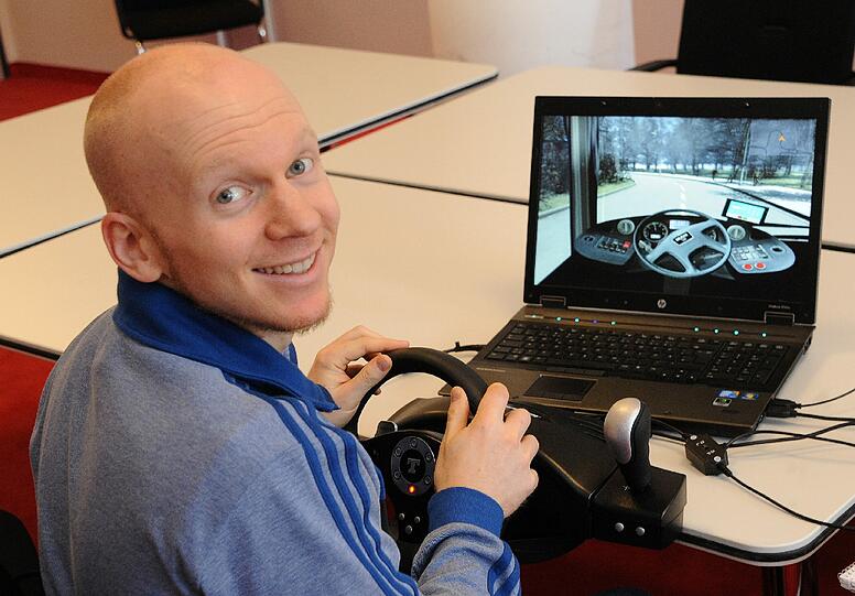 AZ-Redakteur Julian Galinski am Laptop bei der Probefahrt mit dem Bus-Simulator. Gesteuert wird per Lenkrad.