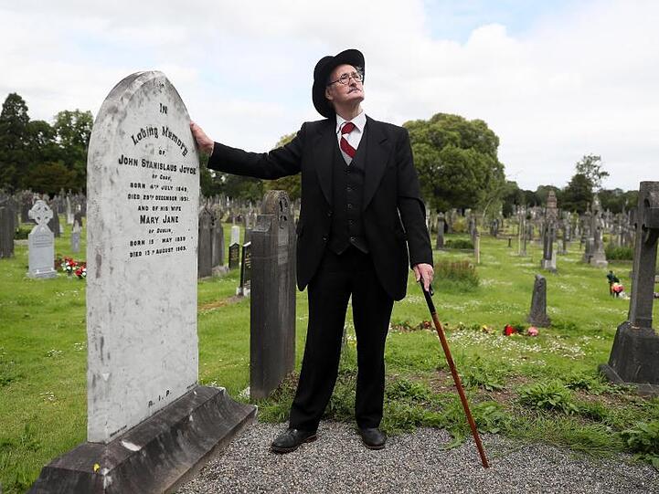 Ein James-Joyce-Darsteller am Grab des Schriftstellers James Joyce und seiner Frau in Dublin (2019).