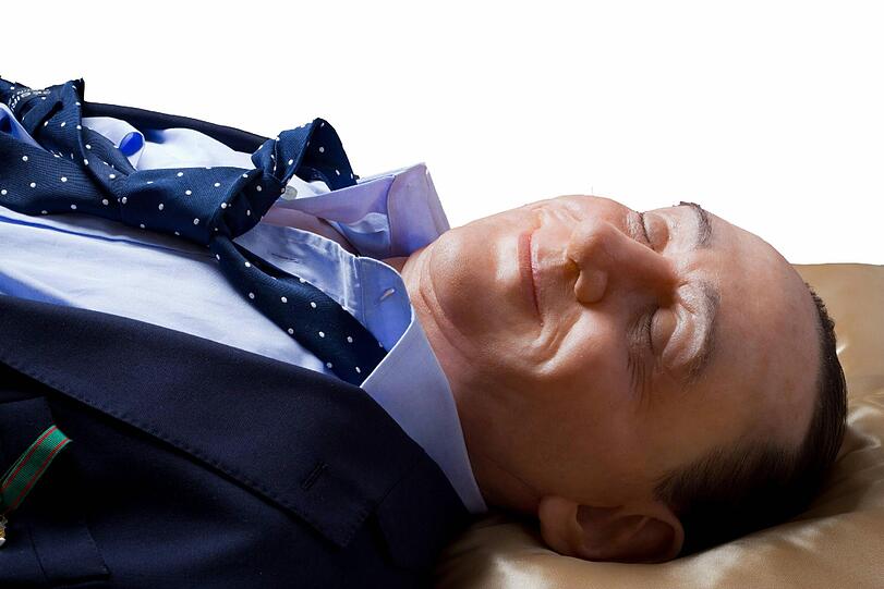Wie ein Heiliger - oder wie Mao und Lenin? - Eine Wachsfigur von Silvio Berlusconi aufgebahrt in einem Glassarg.
