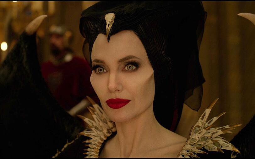 Die Fee Maleficent (Angelina Jolie) versucht, beim Abendessen mit Auroras zukünftigen Schwiegereltern Haltung zu bewahren. Die Fee Maleficent (Angelina Jolie) versucht, beim Abendessen mit Auroras zukünftigen Schwiegereltern Haltung zu bewahren.