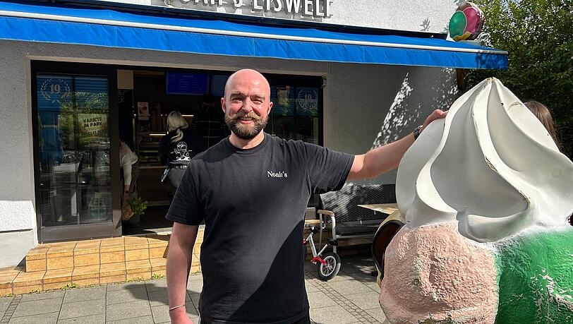 Epizentrum des Mangfallplatzes: Noah&rsquo;s Eiswelt. Sascha Hagl hat den Eisverkauf vor 20 Jahren mit seinem Bruder er&ouml;ffnet. Heute f&uuml;hrt sein Neffe Noah das Gesch&auml;ft. Letztes Jahr wurde das 19-j&auml;hrige Bestehen gefeiert, wie an den Fenstern zu erkennen ist.