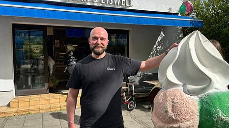Epizentrum des Mangfallplatzes: Noah&rsquo;s Eiswelt. Sascha Hagl hat den Eisverkauf vor 20 Jahren mit seinem Bruder er&ouml;ffnet. Heute f&uuml;hrt sein Neffe Noah das Gesch&auml;ft. Letztes Jahr wurde das 19-j&auml;hrige Bestehen gefeiert, wie an den Fenstern zu erkennen ist.