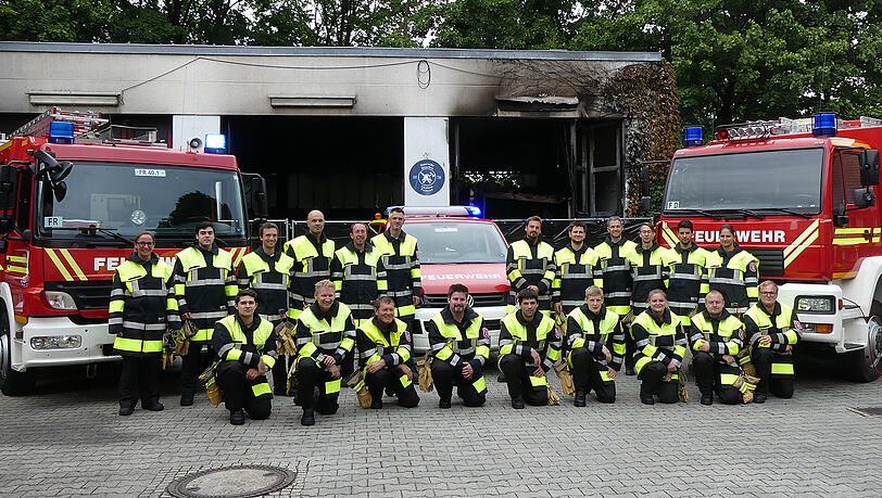 Die Kameradinnen und Kameraden der Freiwilligen Feuerwehr Freimann - im Hintergrund ist die ausgebrannte Fahrzeughalle zu sehen. Die Kameradinnen und Kameraden der Freiwilligen Feuerwehr Freimann - im Hintergrund ist die ausgebrannte Fahrzeughalle zu sehen.