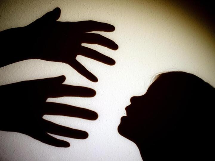 Schatten von Händen einer Person und dem Kopf eines Kindes sind an einer Wand eines Zimmers zu sehen. Foto: Patrick Pleul/dpa-Zentralbild/dpa
