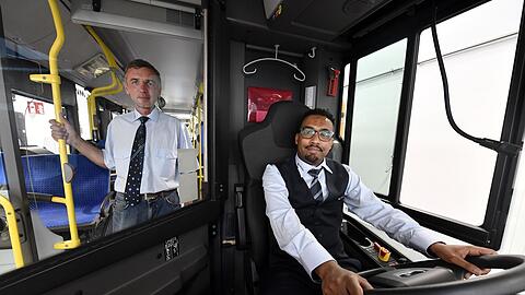 Projektteilnehmer Abdulkarim Youssuf (am Steuer) fährt seit 2023 für die MVG und Vassiliy Kupchik (l.) ist seit Mai 2024 in der Ausbildung zum Busfahrer.