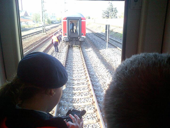 Eisenbahner untersuchen den auf freier Strecke stehengebliebenen Zug.