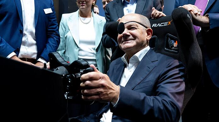Mit Augenklappe hat Kanzler Olaf Scholz die IAA eröffnet. Er ist beim Joggen gestürzt. "Für manche Strecken nimmt man doch lieber das Auto", sagt er.