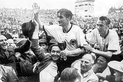 Die Triumphatoren von 1954: Fritz Walter (M, mit dem Pokal in den Händen) und Horst Eckel (r.) werden von den Fans auf Schultern getragen.