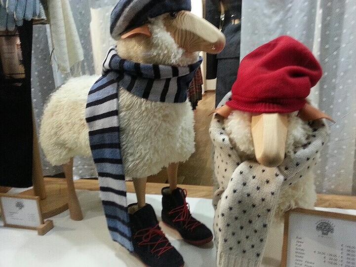 Ein Schaf im Schaufenster, dick eingepackt.