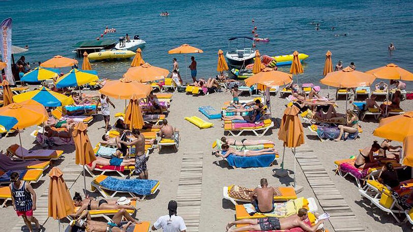 Urlauber genießen die Sonne am Strand der Insel Kos. Der boomende Tourismus ist eine wichtige Einnahmequelle für Griechenland.