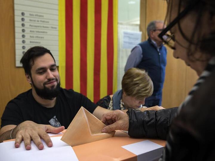 Eine Wählerin gibt ihren Stimmzettel in die Wahlurne in Barcelona.