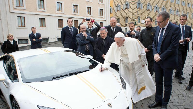 Papst Franziskus signiert den weißen Lamborghini, der ihm vom italienischen Sportwagenhersteller geschenkt wurde. Papst Franziskus signiert den weißen Lamborghini, der ihm vom italienischen Sportwagenhersteller geschenkt wurde.