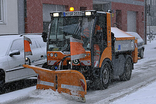 Ein Räumfahrzeug schiebt in München am Donnerstag den frischen Schnee von der Straße