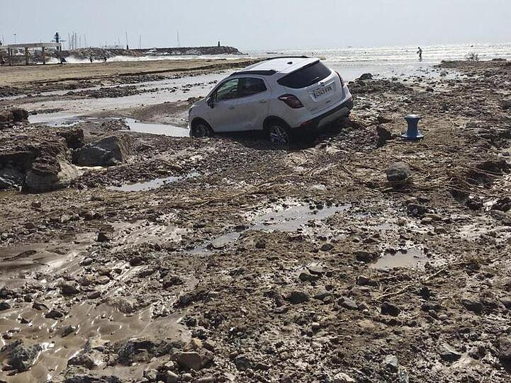 Nach den Überschwemmungen liegt ein Auto in San Jose in Almeria im Schlamm.