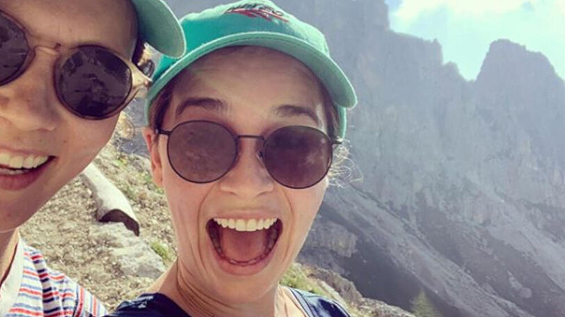 Emilia Clarke strahlt auf dem Berggipfel