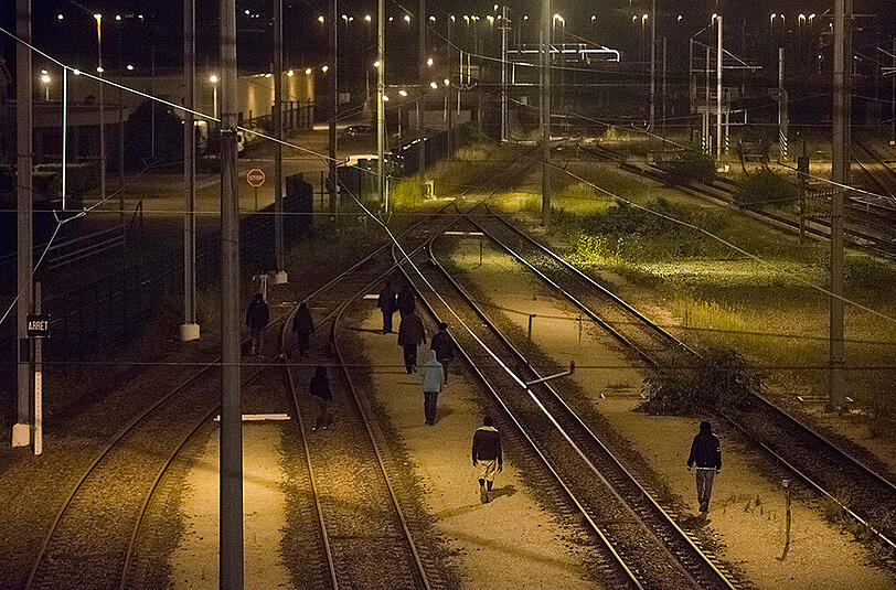 Migranten versuchen in Calais, auf Lastwagen und Züge zu klettern, um nach Südengland zu gelangen.