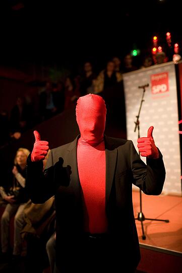 Rot von Kopf bis Fuß: Dieser Anhänger der SPD feiert bei der Wahlparty der Münchner SPD.