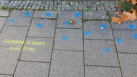 Mit bunten Punkten und Schriftzügen soll auf das Problem von weggeworfenen Kippen hingewiesen werden.