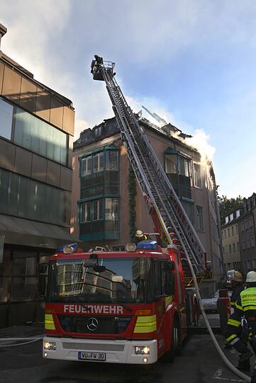 Rauch steigt am Donnerstag aus dem Dachstuhl eines Hauses in der Innenstadt von Würzburg. In den frühen Morgenstunden war der Dachstuhl in Brand geraten. Knapp 100 Feuerwehrleute waren zur Brandbekämpfung im Einsatz.