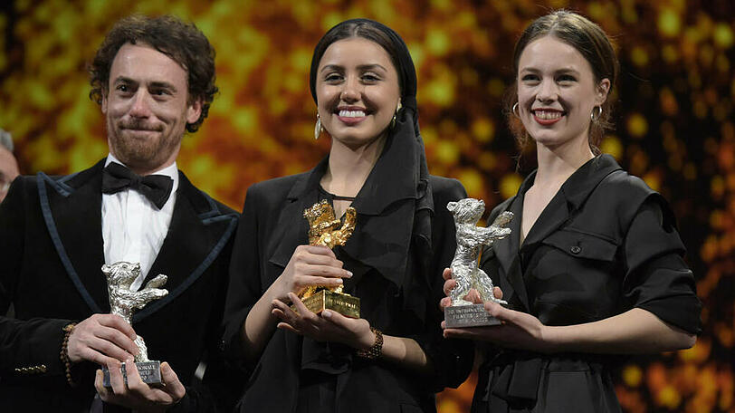 Paula Beer (v.r.), Baran Rasoulof - stellvertretend für den Regisseur Mohammad Rasoulof (Ausreiseverbot) - und Elio Germano bei der Berlinale-Preisverleihung