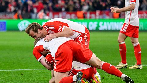 Münchens Harry Kane jubelt nach dem Spiel mit Münchens Eric Dier und Münchens Leon Goretzka.