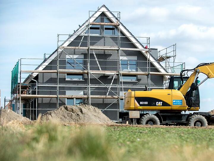 Ein eingerüsteter Rohbau eines Einfamilienhauses steht in einem Neubaugebiet. Foto: Hauke-Christian Dittrich/dpa/Archivbild