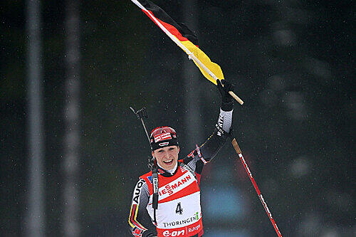 Schon fast ein gewohntes Bild: Magdalena Neuner läuft mit der deutschen Flagge ins Ziel.