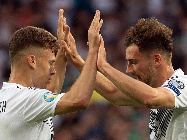Leon Goretzka (r) klatscht mit seinem Teamkollegen Joshua Kimmich ab. Foto: Federico Gambarini/dpa/Archivbild
