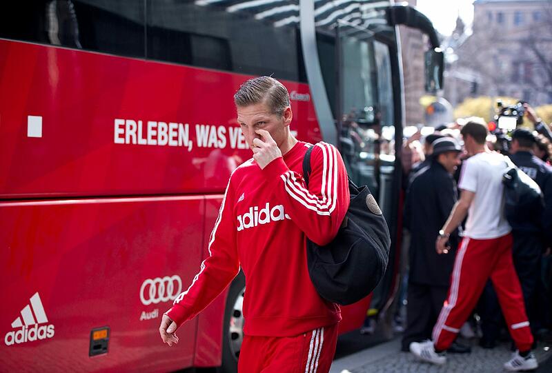 Müde Bayern-Spieler schleppen sich nach einer kurzen Nacht zum Mannschaftsbus.