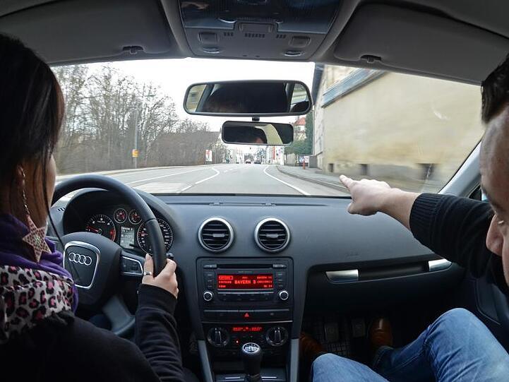 Eine Fahrschülerin sitzt in einem Auto neben ihrem Fahrlehrer. Foto: Armin Weigel/Archiv