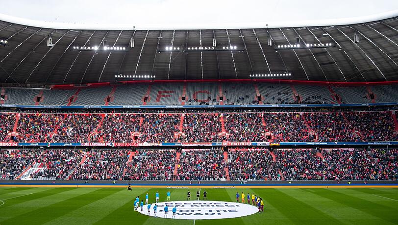 Leverkusens und Münchens Spieler stehen um ein Transparent mit der Aufschrift "Beendet den Krieg! Stop the war!".