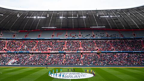 Leverkusens und Münchens Spieler stehen um ein Transparent mit der Aufschrift "Beendet den Krieg! Stop the war!".