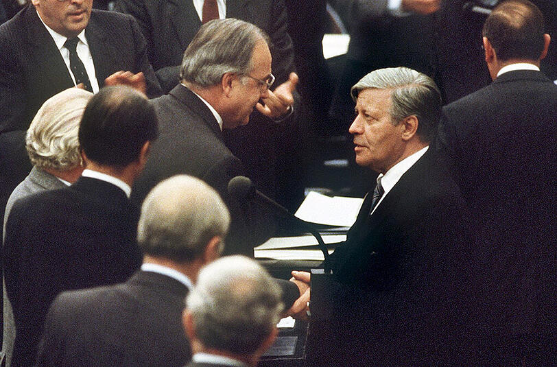1. Oktober 1980: Der gestürzte Bundeskanzler Helmut Schmidt (r, SPD) beglückwünscht seinen Nachfolger Helmut Kohl (M, CDU) zu dessen Wahl im Bundestag in Bonn.