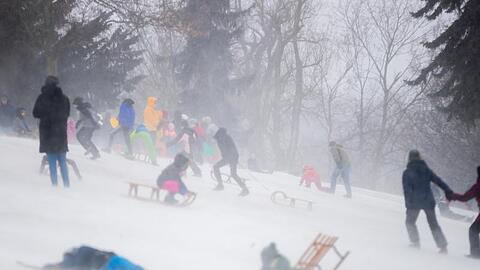 Kinder und Familien rodeln im Volkspark Friedrichshain in Berlin.