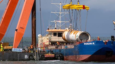 Ein Kranschiff hebt nahe des Lubminer Industriehafens eine Tunnelbohrmaschine vom Meeresboden.
