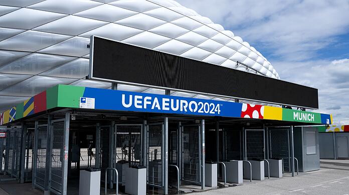 Der Schriftzug "UEFAEURO2024 - MUNICH" ist an einem Eingang von der München Fußball Arena zu sehen.