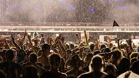 Besucher des Open-Air-Festivals "Rock im Park" verfolgen im Regen ein Konzert. Foto: Daniel Karmann