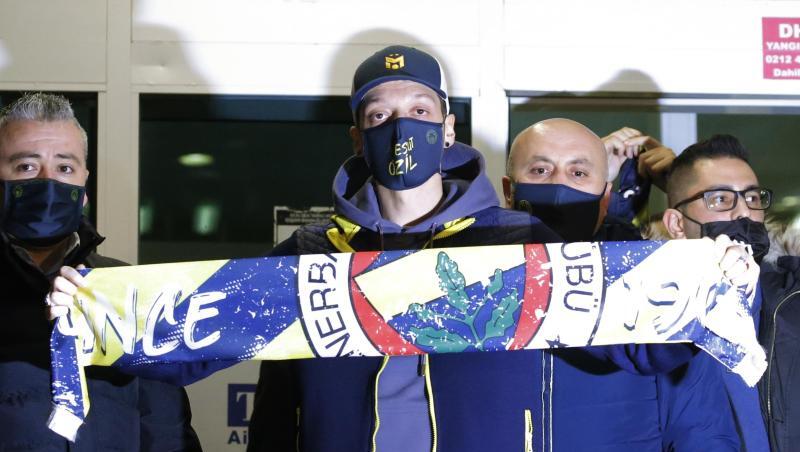Mesut Özil (M.) am Flughafen in Istanbul mit einem Fenerbahce-Schal.