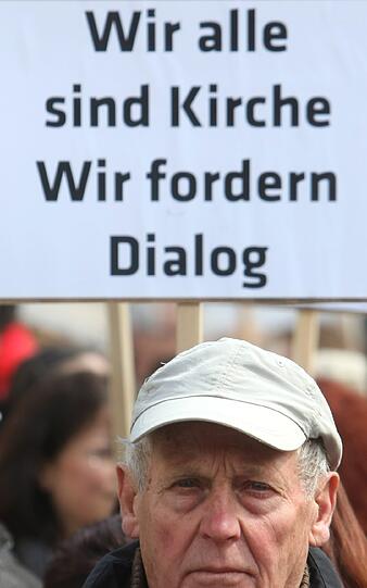 Katholiken stehen am Samstag (21.04.2012) mit Transparenten auf dem Domplatz von Augsburg (Schwaben). Im Rahmen einer Kundgebung demonstrieren sie gegen die geplante Pastoralreform des Bistums Augsburg.